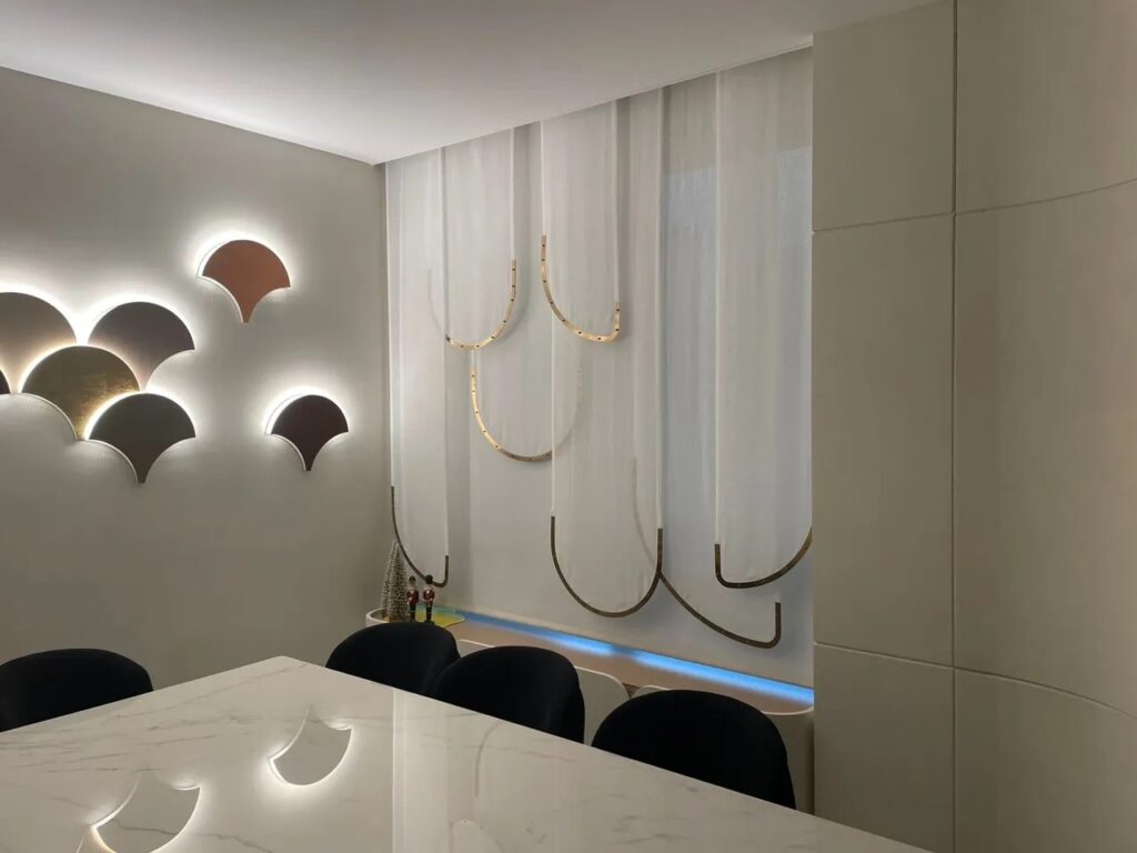 Corner of room with sheer curtains with a striking gold metal edge